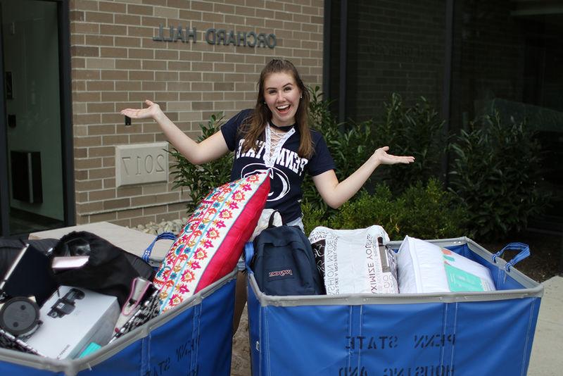 female student standing in front of 果园里 with bins to move in